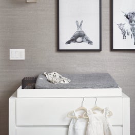 Manhattan contemporary nursery with grasscloth wallpaper and bubble sconces.