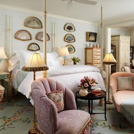 Soft aqua patterned wallpaper creates a tranquil ambiance in this master bedroom