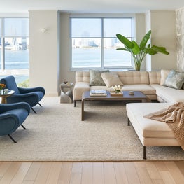 Sectional sofa, bamboo wallpaper and lady chairs complete this room in Tribeca  