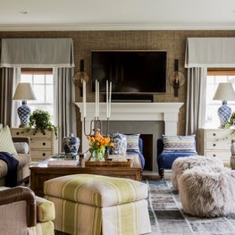 Layered living room with chartreuse blue grey accents fur poufs grasscloth