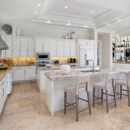 Expansive Decadent Waterfront, marble kitchen, white open concept kitchen, white cabinets, double islands, wet bar, eat in kitchen