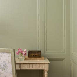 Soft greens and architectural charm abound in this refreshed primary bedroom.