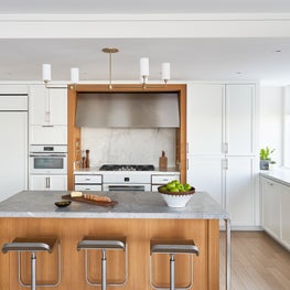 Bright Tribeca kitchen with marble backsplash and contrasting wood island. 