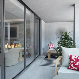 An intricate wall ornament hangs above a wood framed love seat.