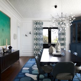 Dramatic Dining Room with pops of color in art and rug, branch chandelier