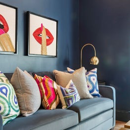 Classic Blue seating area with eclectic wall art & bold patterned throw pillows.