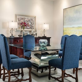  Mediterranean revival chairs surround a unique glass top table.