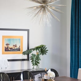 Contemporary starburst chandelier over traditional rich wood dining table.