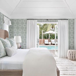 Bedroom, Phillip Jeffries Sequoia White Hemp Wallcovering, RH Marisol Seagrass Slope Bed, Palecek Annabel Hassock Stool, Oscar Isberian Rug