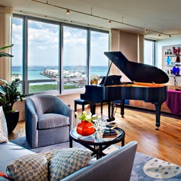 Lake Shore Drive Great Room. Fantastic view of Lake Michigan & Chicago's Navy Pier with a Grand Piano & blue color scheme.