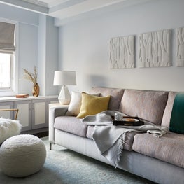 Upper East Side Family Room with stone relief art, furry chair and ombre throw