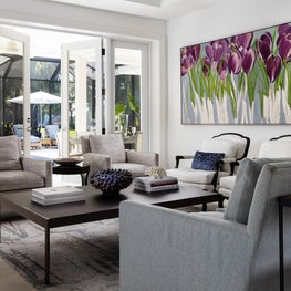 Soft greys are enlivened by a large purple painting.