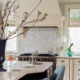 Transitional kitchen with carrara backsplash and blue leather counter stools