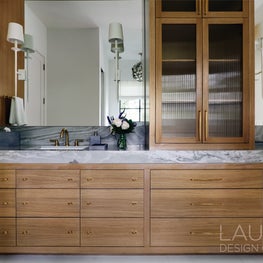 A mitered stone countertop reinforces the bath’s refined, spa-like sensibility.