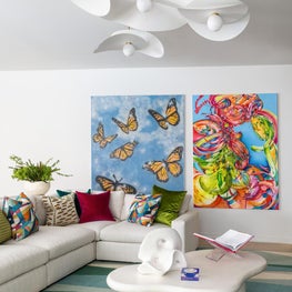 Portfolio: A living room vignette pairs sculptural pendant lighting with large-scale contemporary artwork and layered textiles.