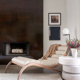 Portfolio: Channel tufted chaise with perennials rug and adjustable side table in front of a floor-to-ceiling fireplace in a Modern Houston home