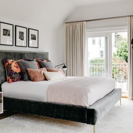 Transitional bedroom with gray and pink upholstered bed, mid-century nightstands