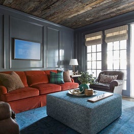 Lake House with dark blue library painted wall paneling and rustic wood ceiling