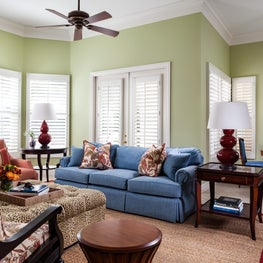  Bold colors and patterns are grounded by a sisal rug with a red boarder.