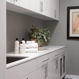 This modern laundry room has a refined edge with clean lines, dynamic tile,  and an integrated dog nook.