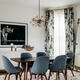 Eclectic mid-century dining room with gray dining chairs and floral curtains