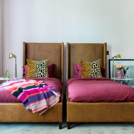 Kid's Bedroom with twin, leather beds, pink walls, and leopard pillows 