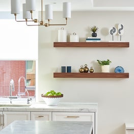 Tribeca all white kitchen features mixed marbles and warm walnut accents. 