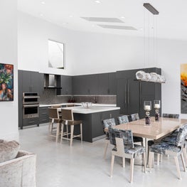 LAKEFRONT CONTEMPORARY VILLA open concept, modern dining room, gray kitchen cabinets, large paintings, modern chandelier