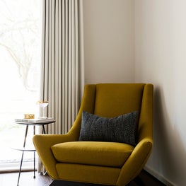 Portfolio: Guest bedroom corner with yellow reupholstered chair with a round side table