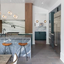 Kitchen, Butler's Pantry, and Dining Room shot showing off custom stone counter tops and backsplash paired with bespoke cabinets