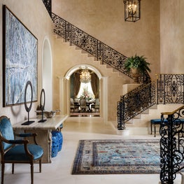 The entry hall in this Palm Beach Estate showcases an antique Persian area rug.