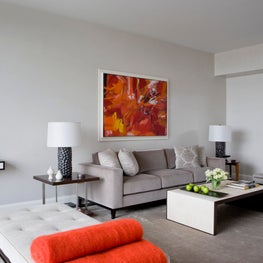 NYC Living Room, modern grey furniture, black and white art with pops of orange