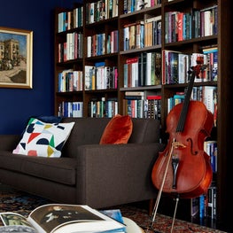 Library with dark brown sofa and colorful accents