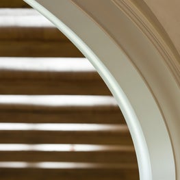 White Painted Jamb Casing Arched Opening with Walnut Beams Beyond