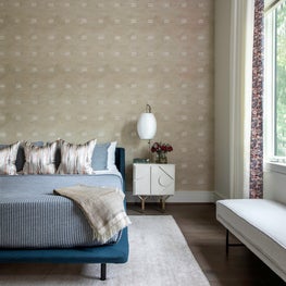 Portfolio: Sophisticated bedroom with a neutral wall covering and blue bed