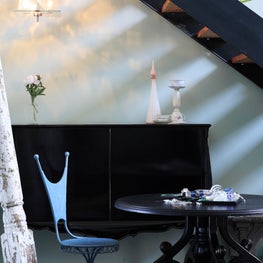 Eclectic Dining Area Tucked Beneath Stairs in Industrial Loft Design