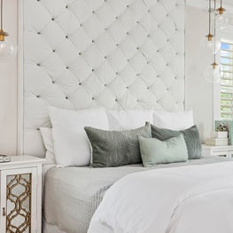 In this transitional bedroom a tufted upholstered headboard adds design texture.