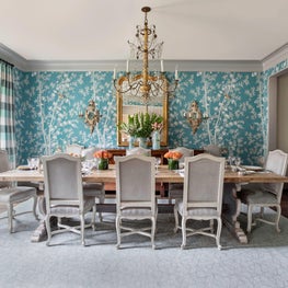 Colorful dining room with floral wallpaper, striped drapes & antique lighting