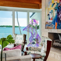 Bold modern art juxtaposes the water views in this organic living room.