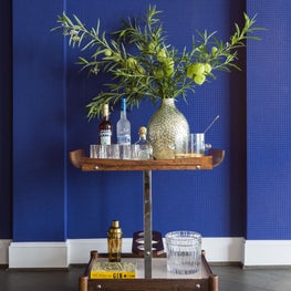Portfolio: Houston high-rise featuring bold cobalt LeCorbusier wallpaper and sleek bar cart