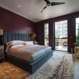 Master Bedroom with patterned rug, colorful walls, and velvet bed frame 