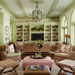 Wicker seating furnishes this versatile indoor-outdoor space with French doors. 