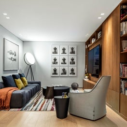 Tie dye rug in the cozy family room is playful with blue and tangerine decor 
