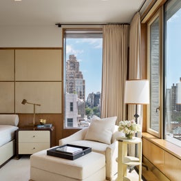 Neutral Penthouse Master Bedroom with Cream Chair