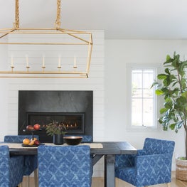 Dining room with shiplap, soapstone fireplace and blue boho dining chairs.