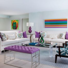 This contemporary living room has colorful eclectic pieces of art and furniture.