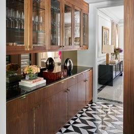 Situated in the hall next to the bar and dining room, this butler's pantry offers the perfect place for their collection of wine bottles and crystal.