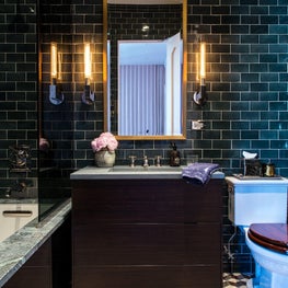 Guest Bathroom with teal subway tile, pattern cement floors, modern sconces