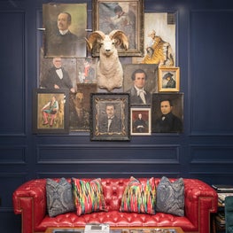 Men's Luxury Clothing Store - custom sofa, antique portraits, mounted ram trophy