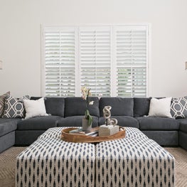 A contemporary family room with sectional & patterned throw pillows & ottomans.